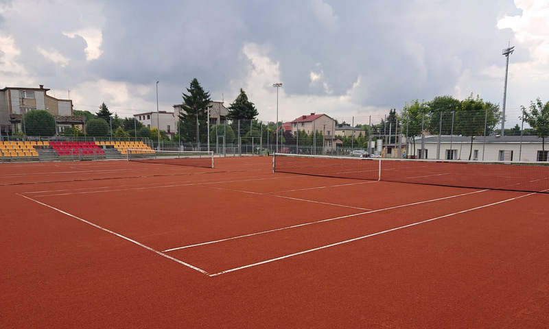 Na zdjęciu widoczne są korty tenisowe wraz z trybuną 
