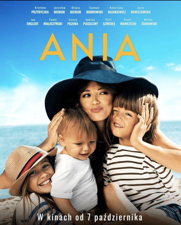 plakat promujący film Ania -  przedstawia główną bohaterkę tulącą swoje roześmiane dzieci