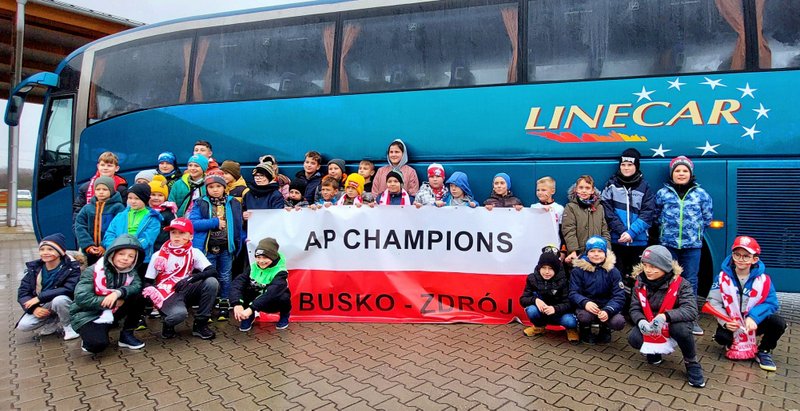 młodzi piłkarze z Akademii Piłkarskiej Champions pozują do zdjęcia przed autobusem