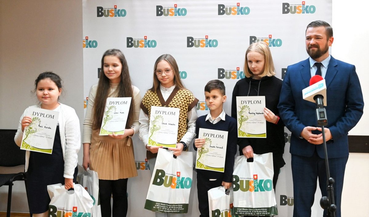 Grupa uczniów - laureatów konkursu  z zastępcą Burmistrza Michałem Marońskim