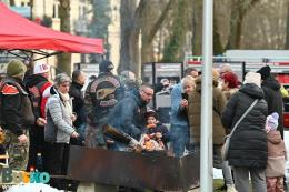 33. Finał WOŚP w Busku-Zdroju - jedno ze stoisk na zewnątrz, osoby przy grillu