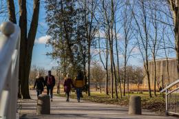Zdjęcie przedstawia spacerujących po Buskim Parku Zdrojowym ludzi.