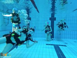 Zdjęcie przedstawia czterech uczestników kursu prezentujących swoje umiejętności pod wodą 