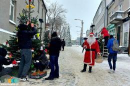 osoby dekorujące świąteczne choinki na placu Zwycięstwa