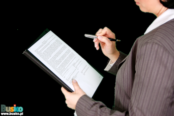 Zdjęcie przedstawia panią trzymającą notatnik i długopis podczas kontroli
