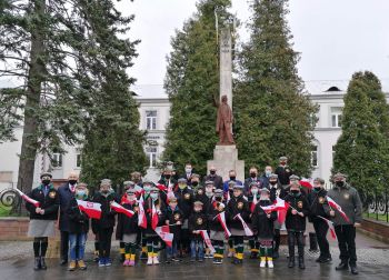 Na zdjęciu znajdują się przedstawiciele władz samorządnych oraz powiatu,  harcerze oraz zuchy buskiego hufca na tle pomnika Tadeusza Kościuszki w Busku-Zdroju.